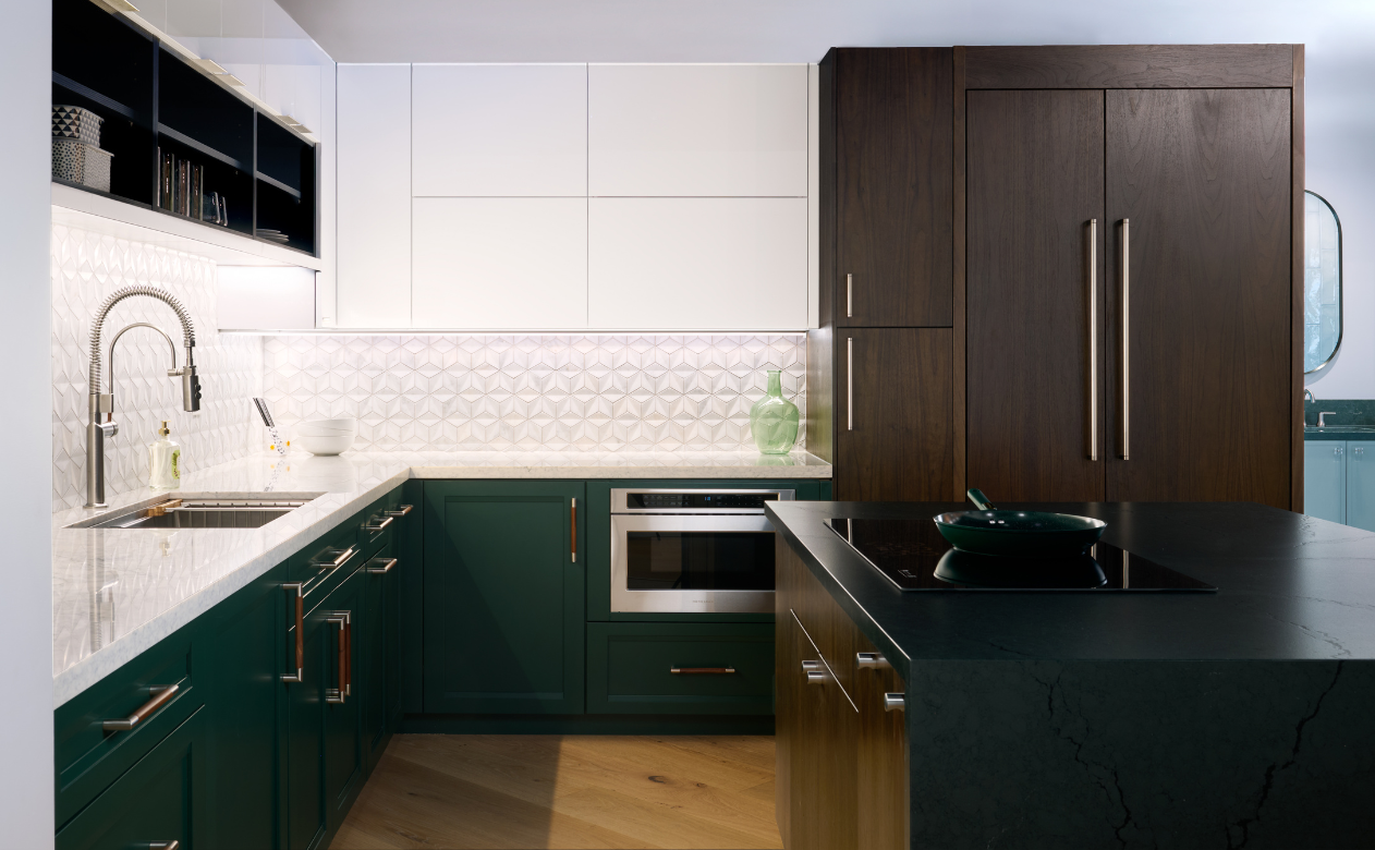 Modern U-shaped kitchen with green lower cabinets, white uppers, geometric backsplash, dark wood island, induction cooktop, marble counters, and herringbone wood flooring.