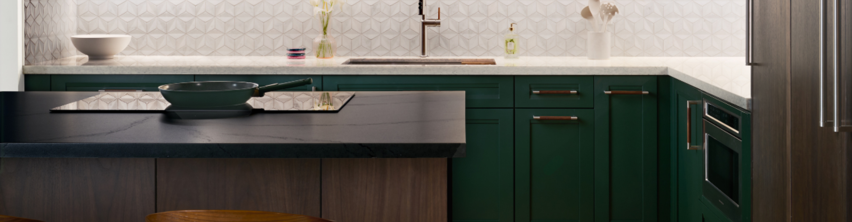 Organized kitchen with dark green cabinets, white countertops, and open shelving for bowls, glasses, and utensils.