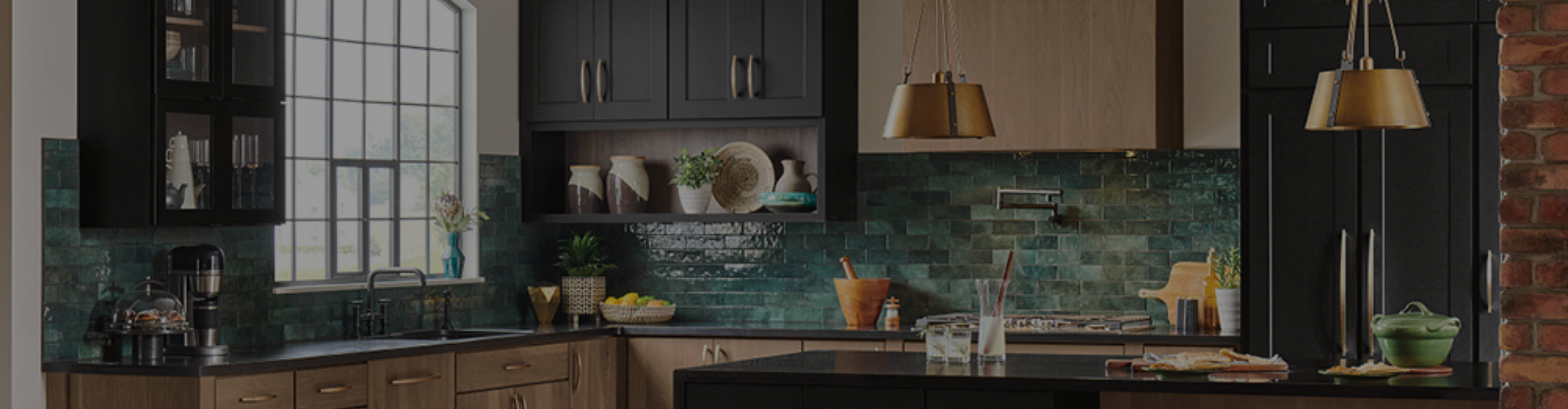 Elegant kitchen featuring golden hardware on cabinets and accent lighting highlighting a green tiled backsplash.